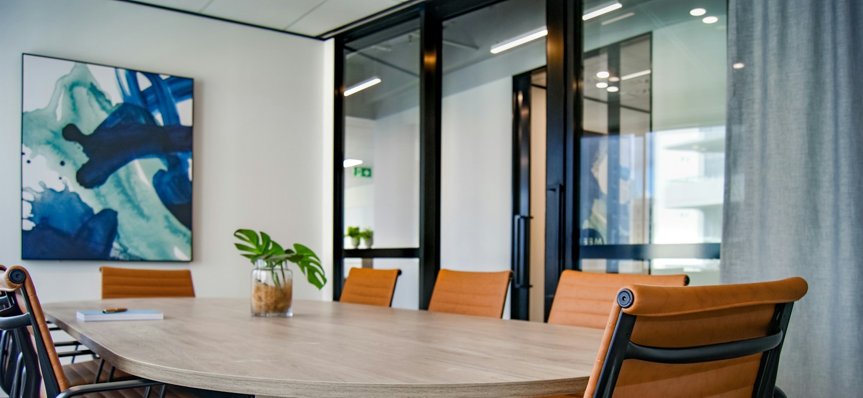Modern office conference room with wooden table and orange chairs